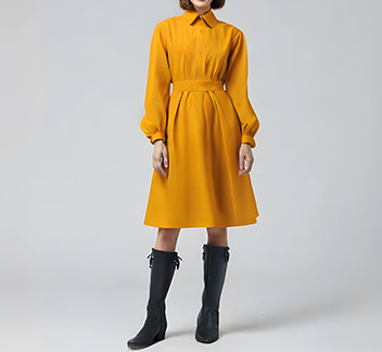 Elegante vestido midi de color mostaza con tonos tierra y corte relajado.